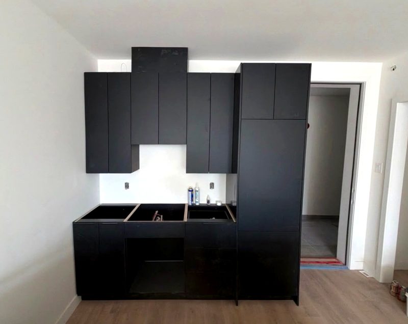 Mur d'armoires de cuisine noires installées par IDC dans un condo de Montréal